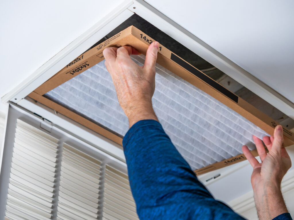 HVAC technician replacing a home air filter in Laguna Niguel
